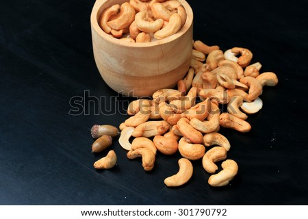 heap cashew nuts and salt on black background