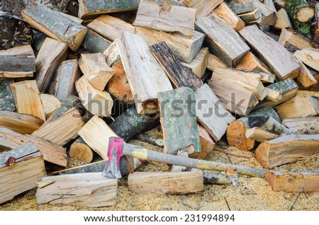 Chopped pile of wood with an axe suggesting fuel for heat during the winter