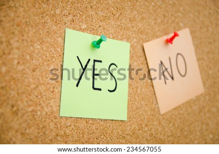 Green YES and red NO post notes pinned to a board with the yes focused in suggesting someone choose positive instead of the other option with a business look