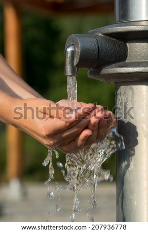 Catching Fresh and Cool Water from a Spring with Hands