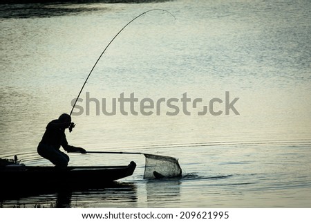 Fisherman Catching Fish on a Twilight Lake