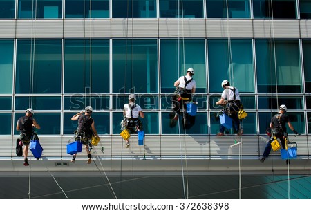 Team Of Climbing Workers Cleaning an Office Building
