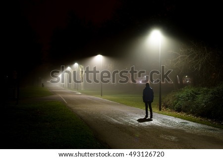 Single Person Walking on Street in the Dark Night