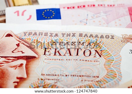 Bank note of the former Greek currency Drachma on a background of Euro bank notes. As Greece has financial problems, a return to the former currency is considered.