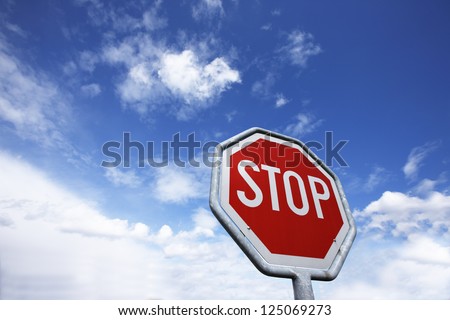 Traffic sign in front of partly cloudy, partly blue sky.