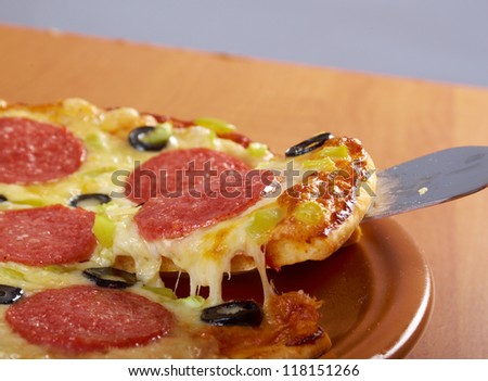 taking slice of pizza,melted cheese dripping.Pepperoni