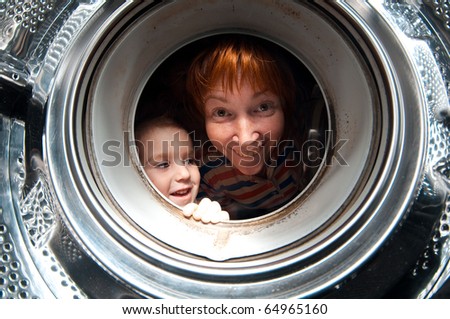 woman and boy peer into get old washer