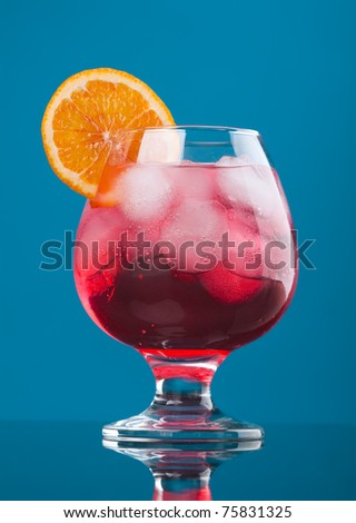 red coctail drink with ice cubs  on blue background.