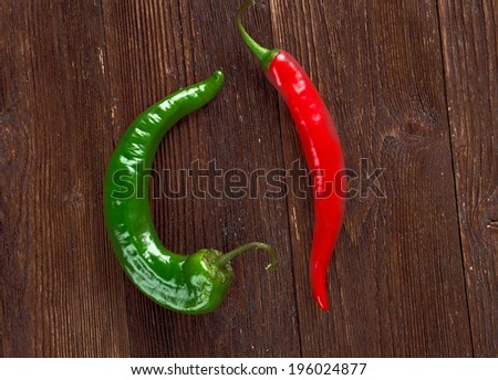 Red and green Hot Chili Peppers over wooden background