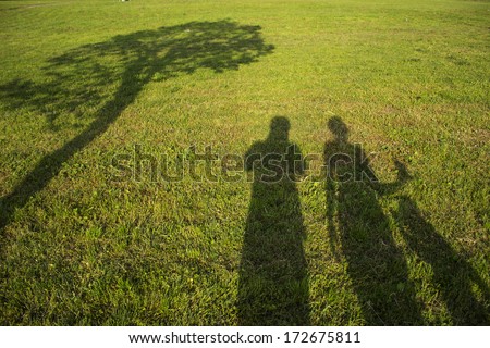 silhouette family with shadows in grass field