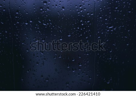 Rainy Nights ,rain drops on glass window ,city lights  in the background