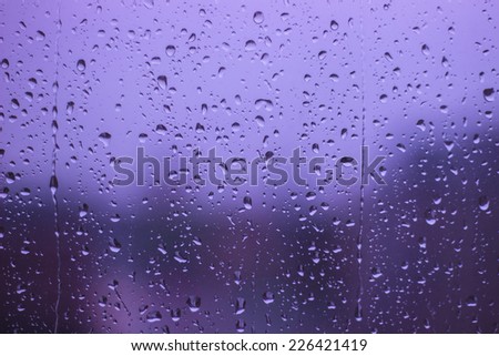 Rainy Days ,rain drops on glass window ,city lights  in the background
