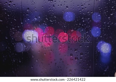 Rainy Days ,bokeh out of focus,rain drops on glass window ,city lights  in the background