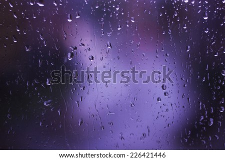 Rainy Days ,rain drops on glass window ,city lights  in the background