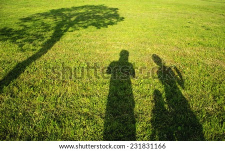family ,parents with kid .shadows in grass field silhouette