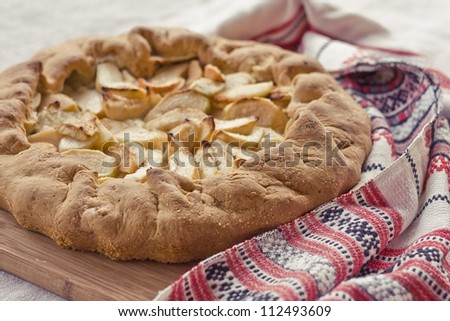 Ukrainian pie with apples decorated with embroidered towel
