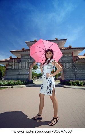 Chinese woman in traditional cheongsam holding umbrella