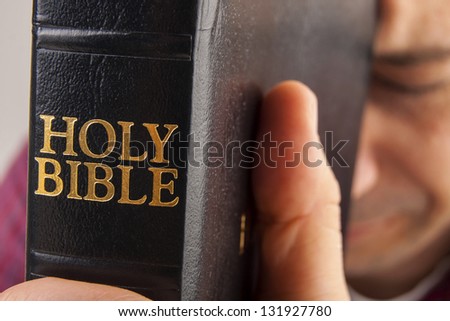 Man Praying Holding the Bible isolated on white