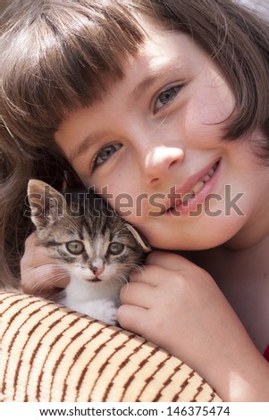 Little girl holding kitten. Outdoor