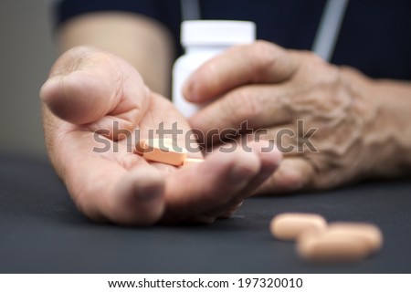 Hands Of Woman Deformed From Rheumatoid Arthritis holding pills