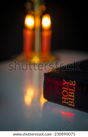 Holy Bible and Candles in Background.