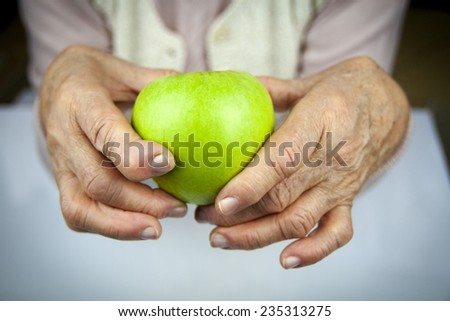 Rheumatoid arthritis hands and fruits. Apple in hand