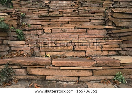 An image of a red stacked stone wall - design detail/background