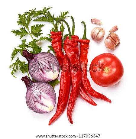 Still life with red chili peppers, tomato, spanish onions, garlic and parsley on white background.