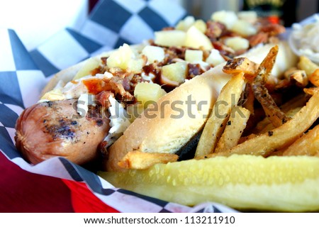 Grilled Hot Dog - Grilled half-pound foot long hot dog topped with bacon, slaw, pineapple chunks, and BBQ sauce.