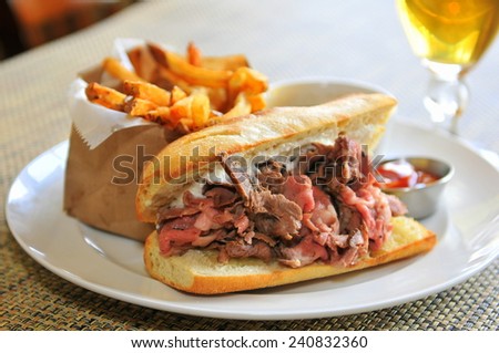 French Dip Sandwich - Juicy smoked prime rib sandwich on a crunchy French baguette smeared with horseradish sauce, and thinly sliced medium rare prime rib and Swiss cheese.