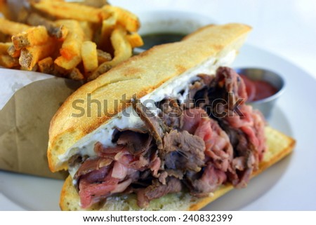 French Dip Sandwich - Juicy smoked prime rib sandwich on a crunchy French baguette smeared with horseradish sauce, and thinly sliced medium rare prime rib and Swiss cheese.