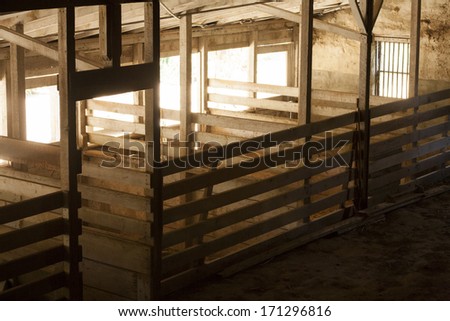 barn interior, like streaming in from the outside into the dark space.