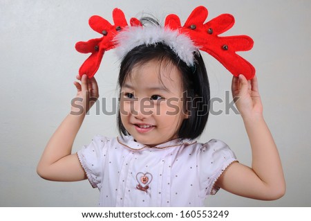 asian little girl wearing a reindeer headband, Christmastime, New Year holiday concept