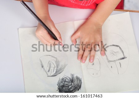 children hand with pencil draws and sketches many human faces