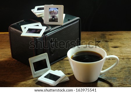 cup of coffee and old film slides of art and culture memories on wooden table