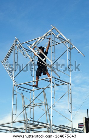 A technician preparing a concert stage equipment tower on a concert stage.