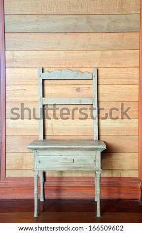 antique wood chair against wooden wall