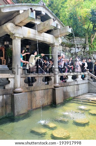 KYOTO,JAPAN - April 18,2014: Japanese people, Shinto believers rinse their mouths and clean their hands before worshiping at shrine in Kiyomisu Temple.