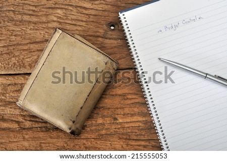 old empty wallet with budgeting plan on wooden table