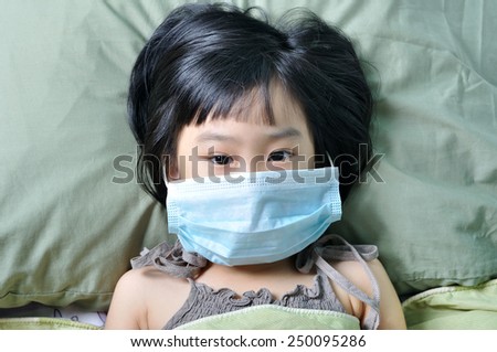 Flu illness little asian girl under blanket in medicine health-care mask