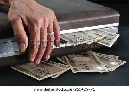 wrinkle senior hand touch suitcase full of Yen cash in dark room, Concept of saving for retirement