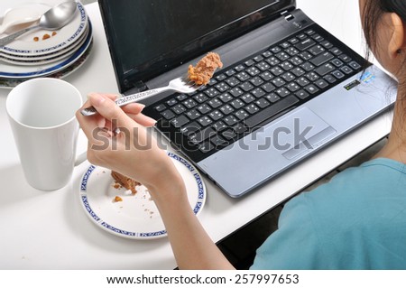 have lunch while busy and using laptop among stack of dirty plates , selective fork focus