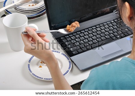 have lunch among stack of dirty plates while busy and using laptop, selective food focus
