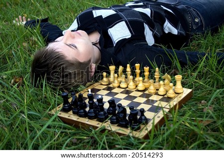 Woman lying in the grass in the yard near the chess board