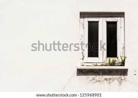 Background: White window on the right hand side of the old white building\'s wall