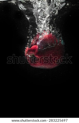 High speed photography of fruits & vegetables with splash in water isolated on black background - APPLE