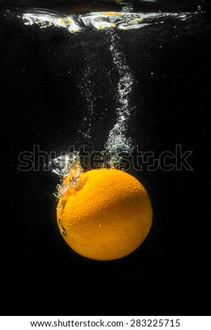 High speed photography of fruits & vegetables with splash in water isolated on black background - ORANGE
