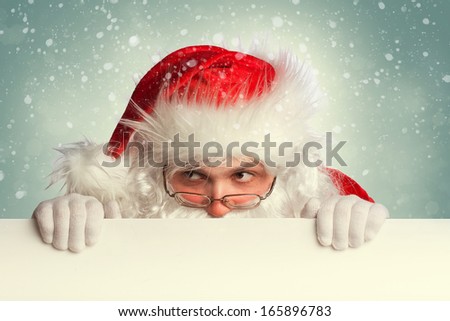 Santa Claus holding white blank banner looking around