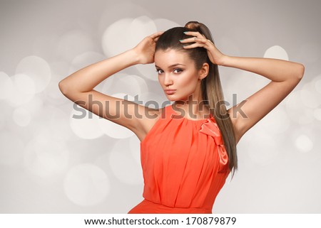 Young female with healthy straghit brown hairs put in pony tail.