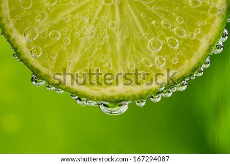 Beautiful fresh slice of lime in the water with bubbles
